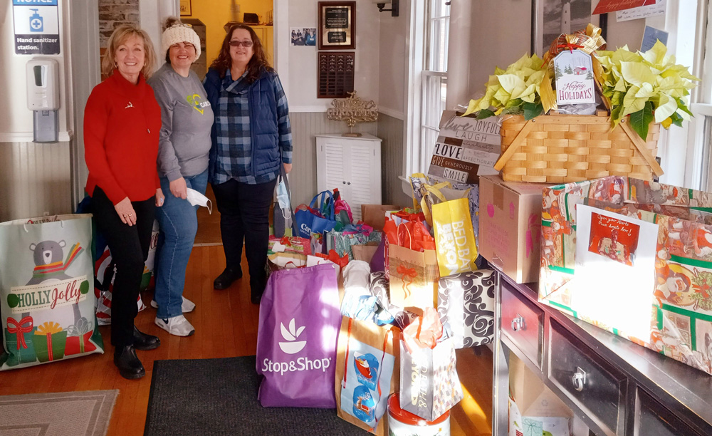 three women standing next to donations