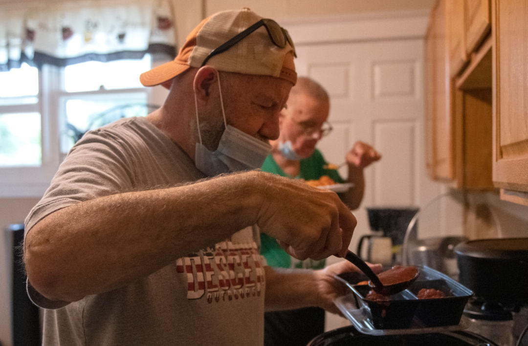 man putting food in a container