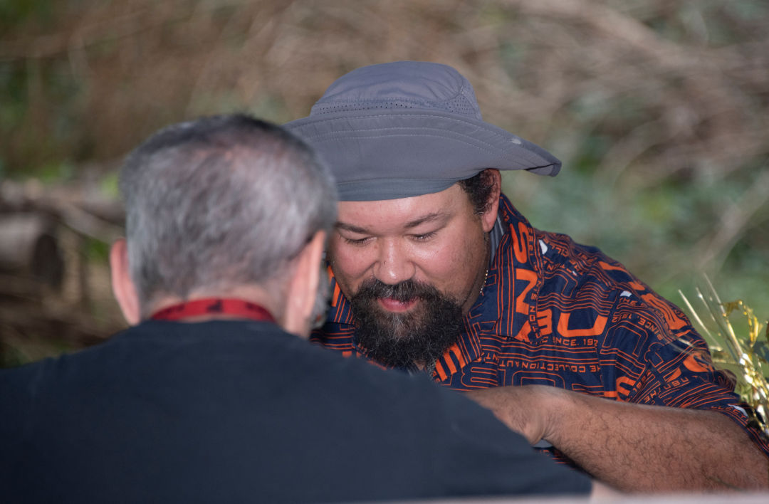 two men sitting down outside