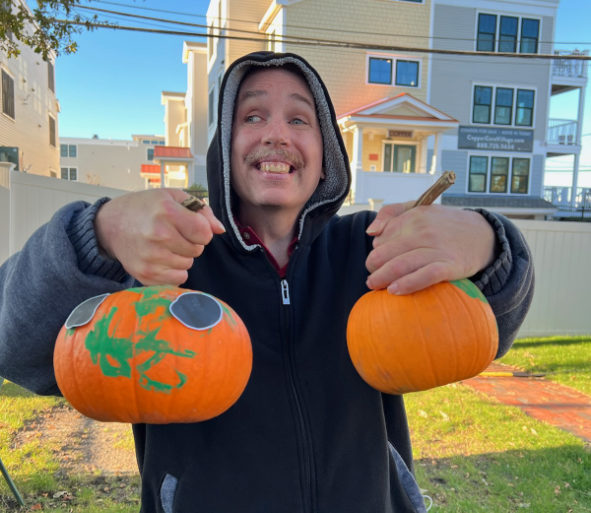 smiling man holding two pumpkins